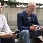 A man and woman engage in a work-related discussion outdoors in London.