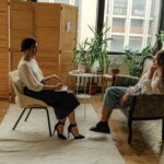 Two women sit in a therapy session, creating a tranquil and professional environment.